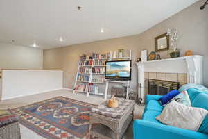 Living room with recessed lighting, carpet floors, a tile fireplace, and baseboards