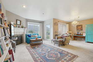 Living area with light colored carpet and a chandelier