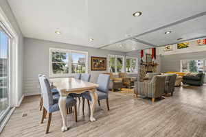 Dining area with visible vents, a stone fireplace, light wood finished floors, and recessed lighting