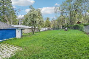 View of yard with a fenced backyard and an outdoor structure