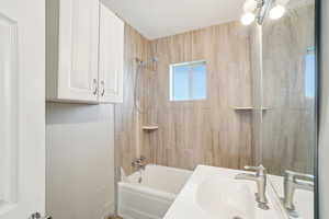 Bathroom featuring a sink and shower / bath combination