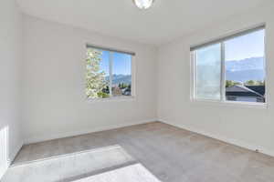 Empty bedroom room featuring baseboards, carpet flooring, and a mountain view