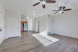 Family living room with light wood-style floors, visible vents, a ceiling fan, and baseboards