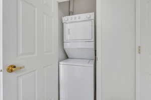 Clothes washing area featuring stacked washer / drying machine and laundry area