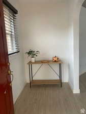 Entryway with arched walkways, wood finished floors, and baseboards