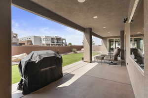 View of patio featuring a fenced backyard and a grill