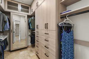 Walk in closet featuring stone tile floors