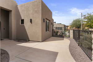 View of side of home featuring a patio area, stucco siding, and fence