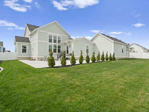 Rear view of house with a lawn, privacy fence, a patio