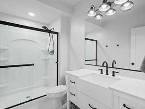 Full bathroom featuring toilet, visible vents, vanity, and a stall shower