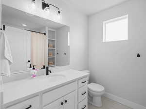 Full bath with baseboards, toilet, and vanity