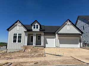 Modern farmhouse featuring a standing seam roof, board and batten siding, and metal roof