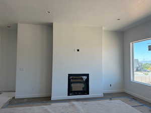 Unfurnished living room with baseboards and a textured ceiling