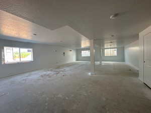 Below grade area with a textured ceiling and healthy amount of natural light