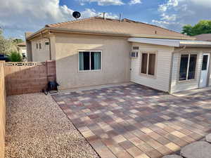 Back of property with fence, a patio, and a wall mounted AC