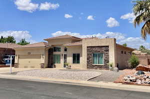 View of front facade featuring stone siding, stucco siding, an attached garage, a tiled roof, and concrete driveway