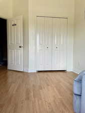 Unfurnished bedroom with baseboards, wood finished floors, and a closet