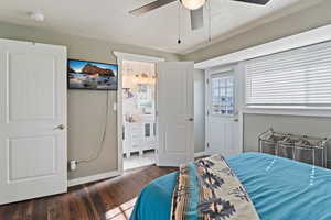 Bedroom with dark wood-style floors, a sink, baseboards, a textured ceiling, and ceiling fan