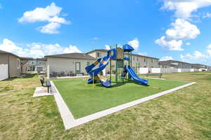 Community jungle gym with a residential view, a lawn, and fence