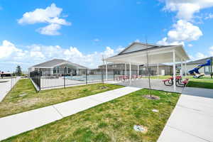 Surrounding community with a lawn, fence, and a swimming pool