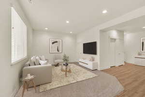 Living area featuring baseboards, recessed lighting, and light wood-style flooring