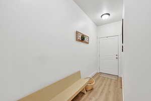 Doorway to outside with baseboards and light wood-type flooring