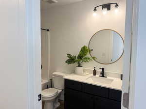 Full bath featuring visible vents, vanity, a textured ceiling, and toilet