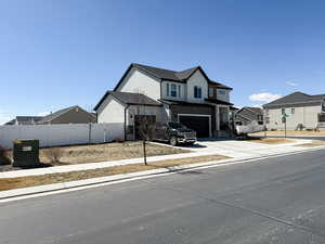 View of front facade with fence, a residential view, stucco siding, an attached garage, and concrete driveway