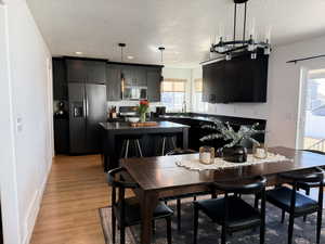 Dining area with a healthy amount of sunlight, a textured ceiling, and light wood-style floors