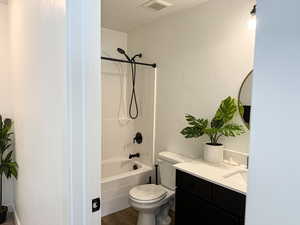 Bathroom with bathing tub / shower combination, visible vents, toilet, vanity, and a textured ceiling