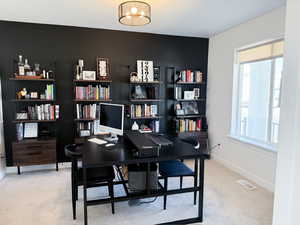 Carpeted home office featuring baseboards and visible vents