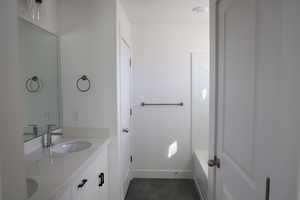 Bathroom featuring tile patterned flooring, a sink, double vanity, and a bathtub