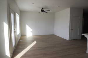 Unfurnished room featuring ceiling fan, baseboards, and light wood-type flooring