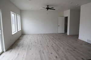 Unfurnished room with light wood-type flooring, visible vents, baseboards, and ceiling fan