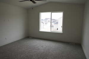 Empty room with ceiling fan, baseboards, lofted ceiling, and carpet