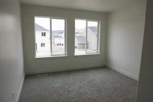Spare room featuring baseboards, visible vents, and carpet