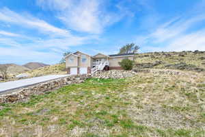 View of front of home featuring stairway, driveway, and a garage