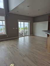 Unfurnished dining room with plenty of natural light, light wood finished floors, baseboards, and recessed lighting