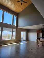 Double story windows to capture the views! Hardwood floors, a ceiling fan, high vaulted wood ceiling
