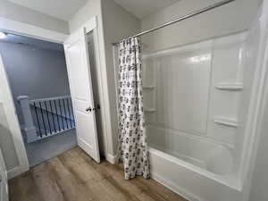 Full bathroom with visible vents, shower / bathtub combination with curtain, and wood finished floors