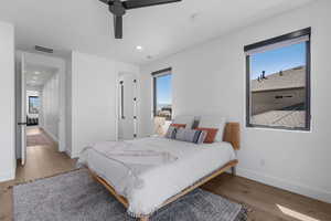 Bedroom featuring wood finished floors, visible vents, baseboards, and multiple windows