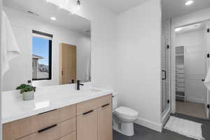 Bathroom featuring tile patterned floors, a stall shower, vanity, toilet, and visible vents