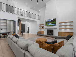 Living room with light wood-style flooring and a high ceiling