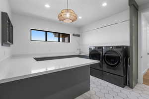 Laundry room featuring washing machine and clothes dryer, laundry area, and recessed lighting