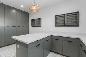 Laundry with a peninsula, recessed lighting, gray cabinets, and light countertops