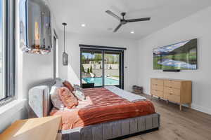 Primary Bedroom featuring light wood finished floors, baseboards, recessed lighting, and access to exterior