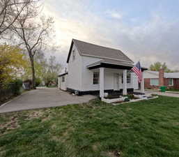 Rear view of property featuring stucco siding, roof with shingles, fence, and a yard