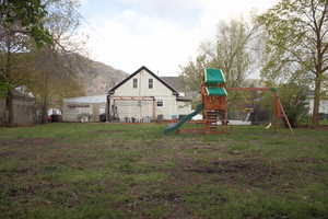 View of jungle gym with a lawn and a mountain view