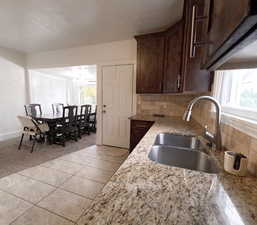 Kitchen with a sink, a notable chandelier, tasteful backsplash, and a healthy amount of sunlight