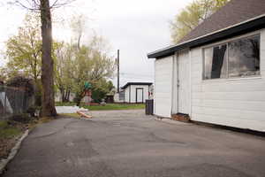 Exterior space featuring roof with shingles, fence, an outbuilding, and a playground